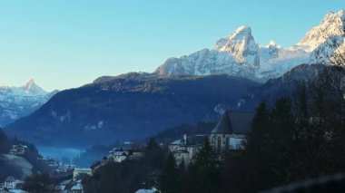 Sabahleyin Watzmann Dağı 'nın manzarası. Güzel dağ manzarası, orman, sis ve şehir binaları. Watzmann Dağı, Bavyera 'nın güneydoğusunda. Şehir ve doğa. Almanya