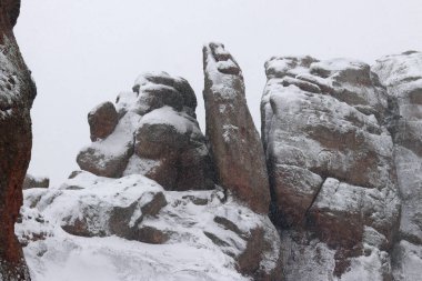 Karla kaplı Belogradchik kayaları. Bulgaristan. Kış havasında olağandışı şekillerde kaya oluşumları. Kar yağışı. Doğal dönüm noktası. Belogradchik şehri yakınlarındaki kayalar. Doğa