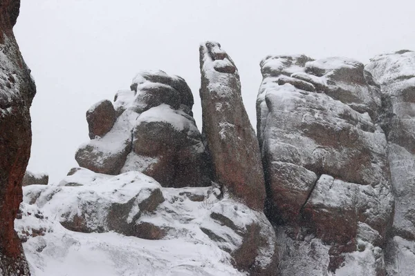 Karla kaplı Belogradchik kayaları. Bulgaristan. Kış havasında olağandışı şekillerde kaya oluşumları. Kar yağışı. Doğal dönüm noktası. Belogradchik şehri yakınlarındaki kayalar. Doğa