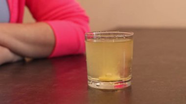 Köpüren tabletli bir bardak su. Coşkulu tabletlerdeki C vitamini. Vitamin ve ilaçlar. Çözülebilir vitamin ve kadın eli yığınlarına yakın çekim. Suda çözünen vitamin süreci