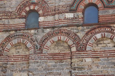 Nessebar, Bulgaristan - 25 Ağustos 2025: Christ Pantocrator Kilisesi. Ortaçağ Ortodoks kilisesinin dış görünüşü. Geç Bizans tarzında. Renkli dekor ve seramik elementlerle ön cephe