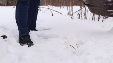 Tanımlanamayan bir kişi metal bir kürekle karı kaldırıyor. Kışın kar temizlemek için bir kürek. Kürekte demiryolu çeliğinden yapıldığına dair bir yazı var. Bölgeyi kardan temizliyorum.