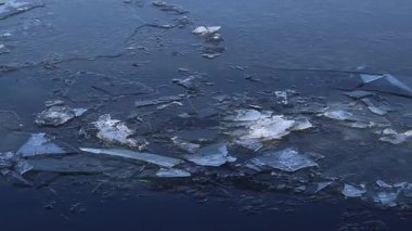 Çatlak erimiş buz nehrin yüzeyi boyunca hareket eder. Buz, saydam buz tabakalarının yüzeyde görülebilmesinden dolayı kısmen kırılmıştır. Nehirde eriyen buz. Kış