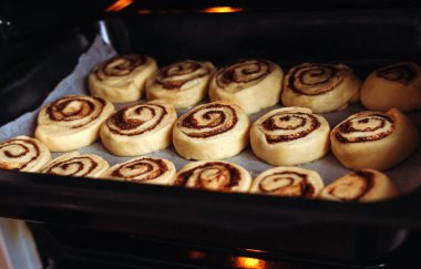 Şekerli çörekler ve tarçınlı fırın. Çörek günahı yapma süreci. Yakın plan. Seçici odak.