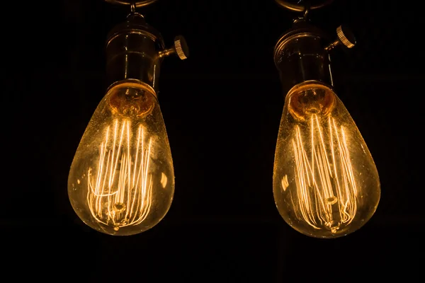 Vintage Edison Lâmpadas penduradas contra um fundo preto — Fotografia de Stock