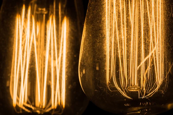 Vintage Edison Lâmpadas penduradas contra um fundo preto — Fotografia de Stock