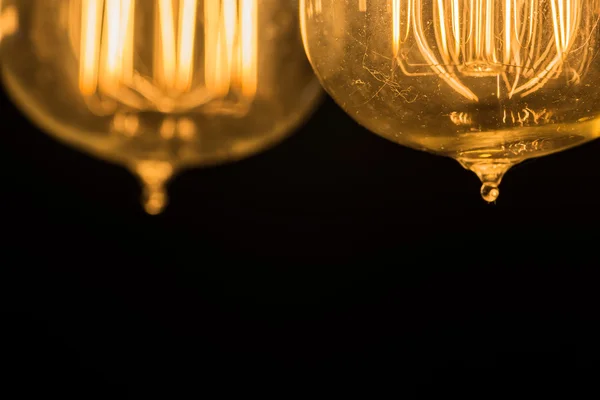 Vintage Edison Light Bulbs hanging against a black background — Stock Photo, Image