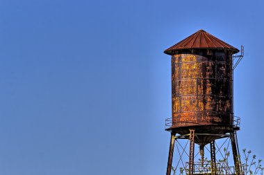 Mavi gökyüzü arka plan ile eski, rustik su kulesi