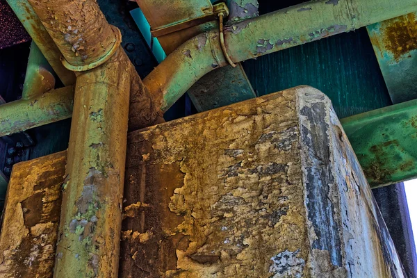 Rusty, velho, tubo sob uma ponte ferroviária — Fotografia de Stock