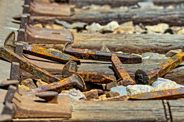 Rusty railroad spikes laying on ground in a pile — Stock Photo, Image