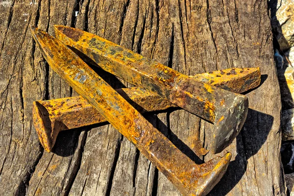 Rusty railroad spikes laying on ground in a pile — Stock Photo, Image