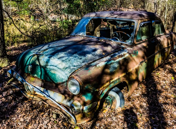 Rusty, viejo, coche chatarra en el bosque — Foto de Stock