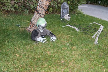 Kenar mahallelerin arka bahçesinde Cadılar Bayramı süslemeleri. Karnaval maskeli bir uzaylı, renkli turuncu renkli ışıklar ve miğfer taşı taşıyla süslenmiş. 