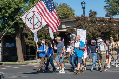 Davis, CA, 18 Ekim 2025. Donald Trump 'a karşı düzenlenen protesto sırasında göstericiler bir Amerikan bayrağı ve Kral Yok ve ICE işareti taşıyorlar