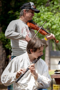 Çim Vadisi, 03 Mayıs 2025. 2025 yılında Grass Valley 'deki Kelt Festivali' nde, iki müzisyen geleneksel müzikle kalabalığa ilgi gösterdi. Bir müzisyen ayakta dururken keman çalar, diğeri otururken flüt çalar..