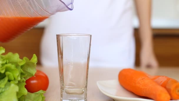 Close-up of glass with pouring carrot juice. — Stock Video