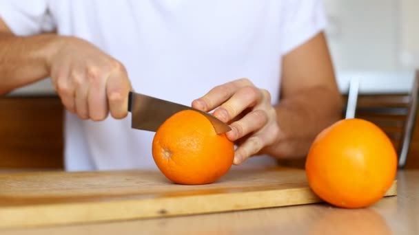 Man skär orange på hugga ombord närbild på vit bakgrund — Stockvideo