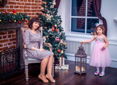 Noel ağacının yanında oynayan kızıyla birlikte mutlu anne