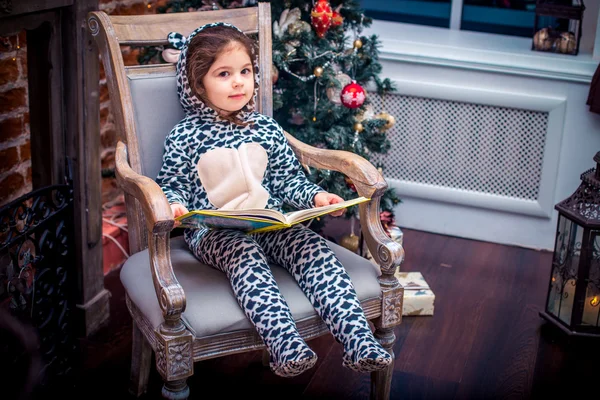 Όμορφο κοριτσάκι χαμογελώντας με αρκουδάκι κοντά το χριστουγεννιάτικο δέντρο σε vintage καρέκλα. Ευτυχισμένος ο καινούριος χρόνος. — Φωτογραφία Αρχείου