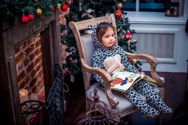 Menina bonita sorrindo com ursinho de pelúcia perto da árvore de Natal sentado na cadeira vintage. Feliz Ano Novo . — Fotografia de Stock