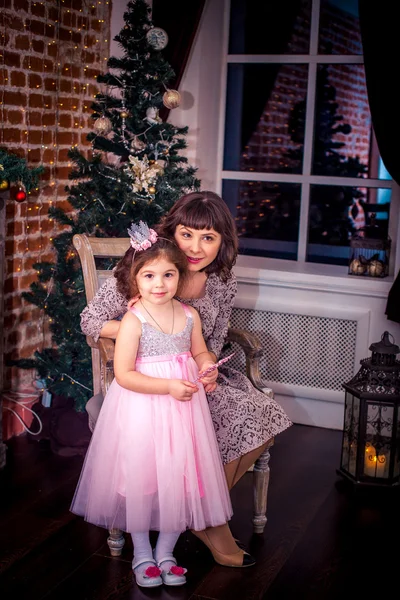 Bonne mère avec sa fille près de la cheminée près de l'arbre de Noël — Photo