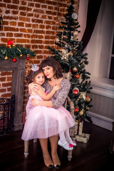 Bonne mère avec sa fille près de la cheminée près de l'arbre de Noël — Photo