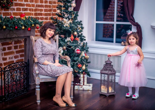 Ευτυχισμένη μητέρα με την κόρη της παίζει κοντά το χριστουγεννιάτικο δέντρο — Φωτογραφία Αρχείου