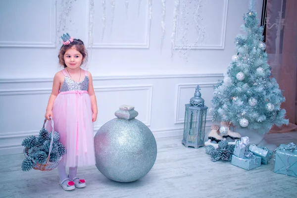 Menina vestida de forma bonita vestido de flor branca posando perto da árvore de Natal — Fotografia de Stock