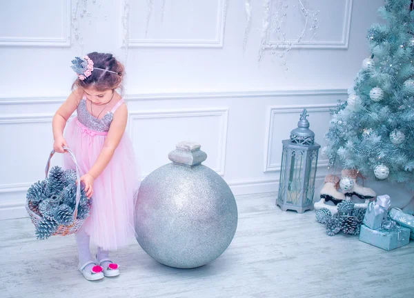 Kis lány öltözött szép divat fehér virág ruha pózol a karácsonyfa közelében — Stock Fotó
