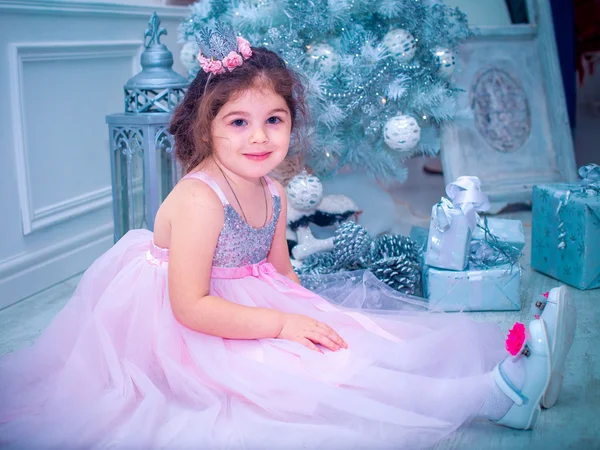 Menina vestida de forma bonita vestido de flor branca posando perto da árvore de Natal — Fotografia de Stock