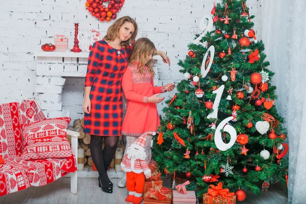 Mère en robe rouge sourit et tient un beau bébé — Photo