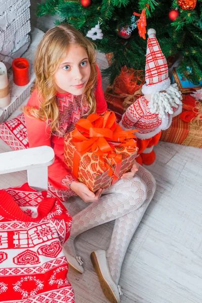 Menina festiva abrindo um presente em casa — Fotografia de Stock