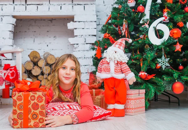 Menina festiva abrindo um presente em casa — Fotografia de Stock