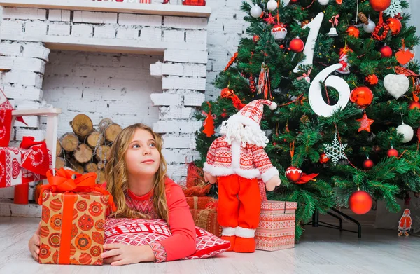 Menina festiva abrindo um presente em casa — Fotografia de Stock