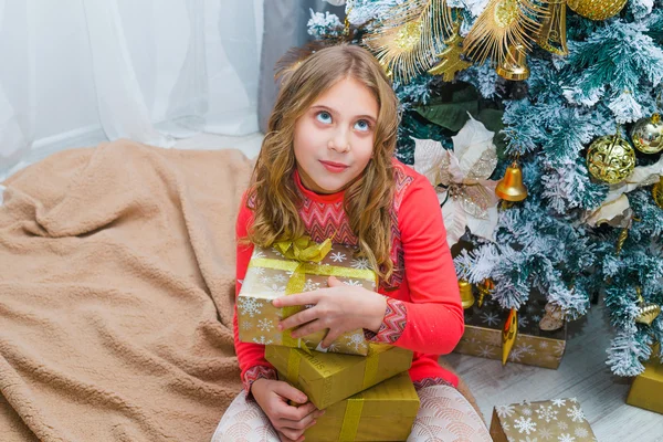 Menina festiva abrindo um presente em casa — Fotografia de Stock