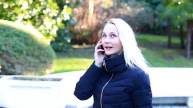 Genç kız mobil cep telefonu gülümseyen, açık havada konuşuyor. Mutlu kadın
