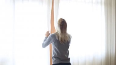 Güzellik kız perdeleri büyük penceresinde açılır ve odadaki ışık girsin. Pencereden dışarı bakıp