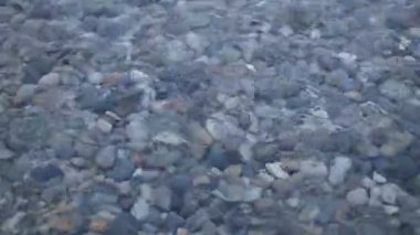 Dalgalar ve temiz su. Su üzerinden görünür taşları vardır. Nehirler, göller ve deniz.