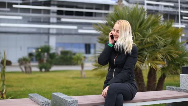 Chica joven hablando en el teléfono móvil sonriendo, al aire libre. Mujer feliz — Vídeos de Stock