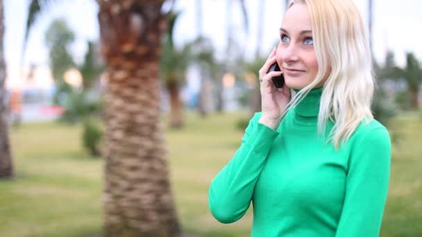 Jovem falando no celular sorrindo, ao ar livre. Mulher feliz — Vídeo de Stock