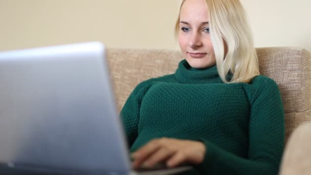 Mujer bastante joven usando el ordenador portátil mirando a la cámara y sonriendo — Vídeos de Stock