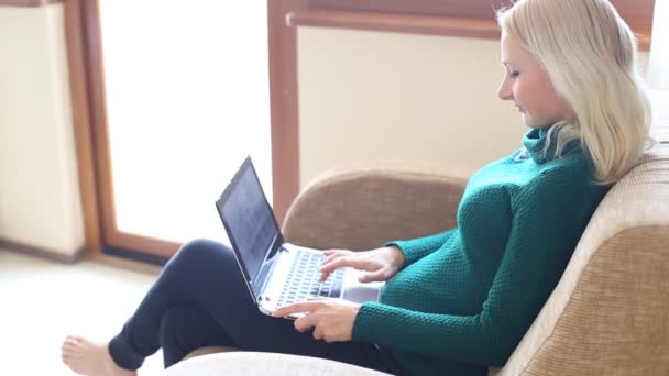 Mooie jonge vrouw met behulp van de laptop kijken camera en glimlachen — Stockvideo