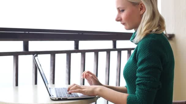 Mooie jonge vrouw met behulp van de laptop kijken camera en glimlachen — Stockvideo