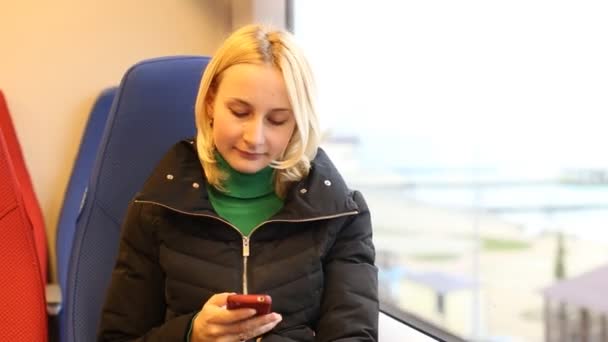 触摸手机短信写作，在火车的年轻女子 — 图库视频影像