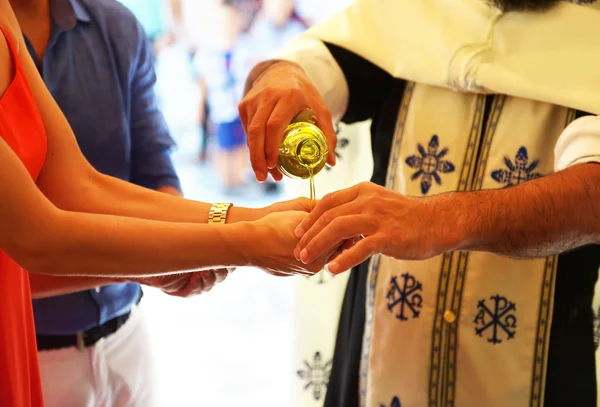Ortodoxní křest ikony - kněz klade křest olej na ruce kmotra — Stock fotografie