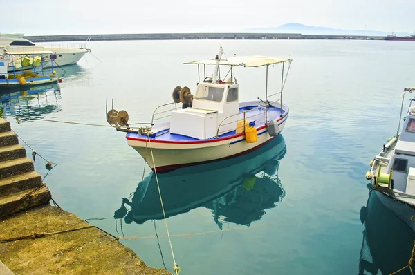 Fishing boat reflected on sea — Stock Photo, Image