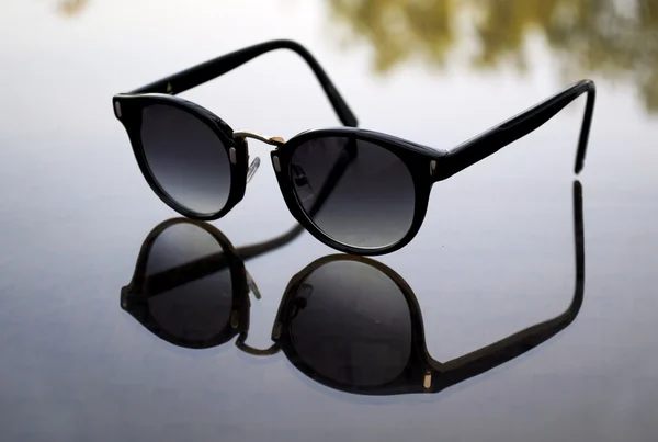 Sunglasses on table reflection — Stock Photo, Image