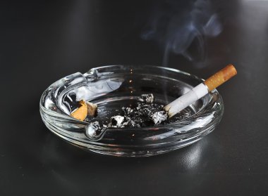kül tablası içinde sigara yaktı
