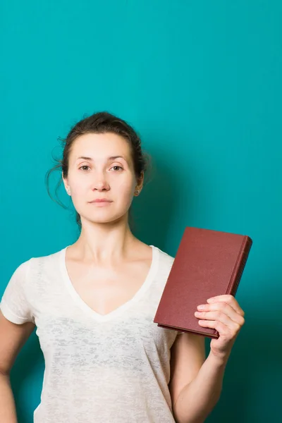 Mooie brunette meisje met boek in de hand — Stockfoto