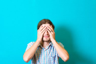 Elleriyle gözlerini kapatan genç bir adamın portresi.